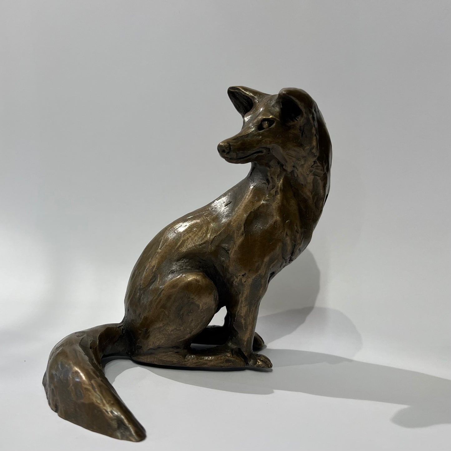 Bronze sculpture of a fox on a white background