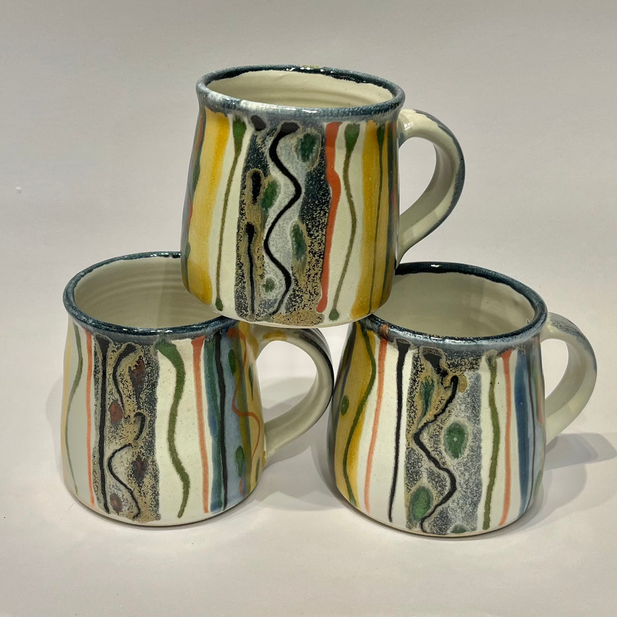ceramic mugs with a hand-painted abstract design made by lea Phillips